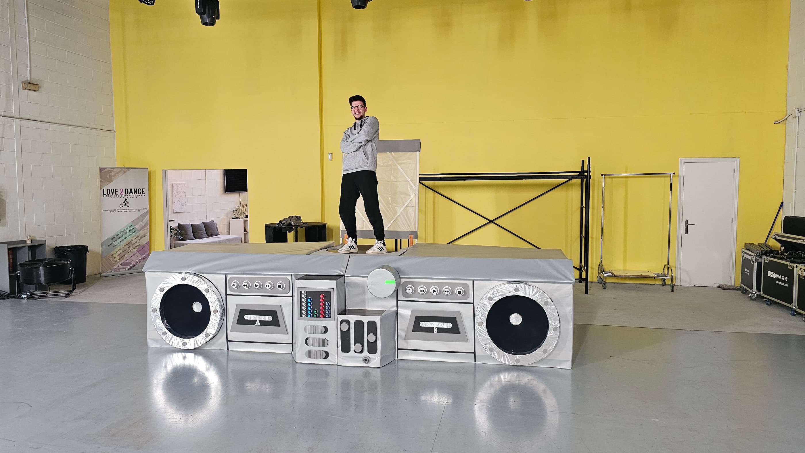 El radiocasete gigante terminado, con una persona de pie encima que da la medida de su tamaño.